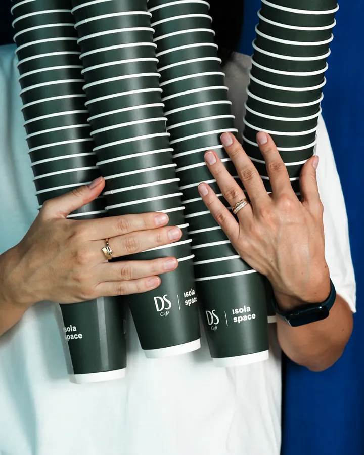 Stacks of olive green DS cups carried in arms